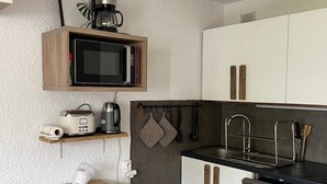Eine kleine Küche mit Mikrowelle, Toaster und Spüle.