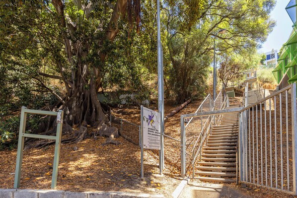 A staircase leading up to a building with a metal railing and a signboard. - City Escape Mounts Bay Apartment. Near Kings Park -  Parking - Wifi (Perth)