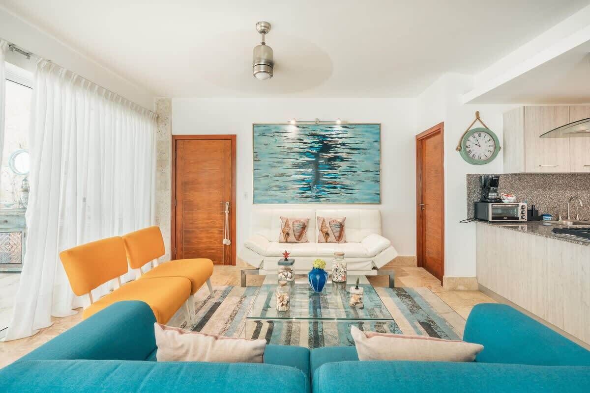 A modern living room with a sofa, coffee table, and artwork.