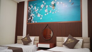 A hotel room with two beds, a large wall mural, a round mirror, and a wooden panel design. - Sunrise Ninh Binh Hotel (Hoa Lu)
