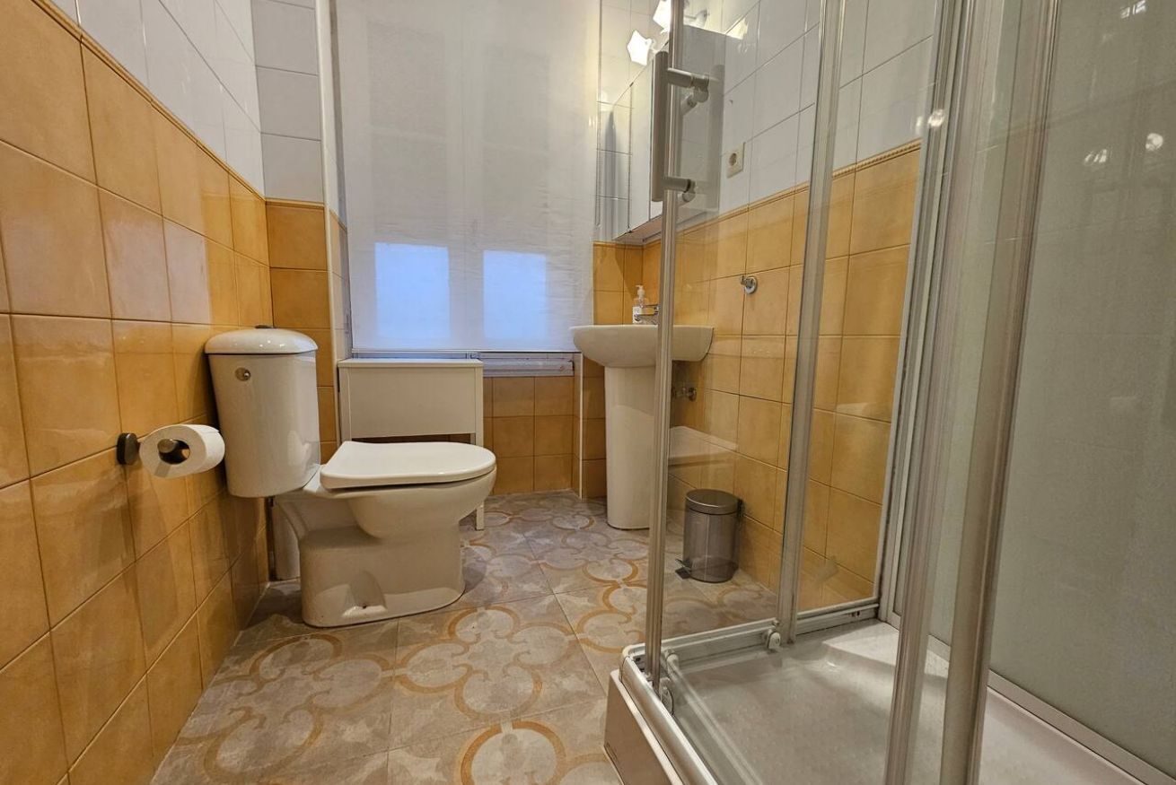 Un baño con inodoro, lavabo y ducha.