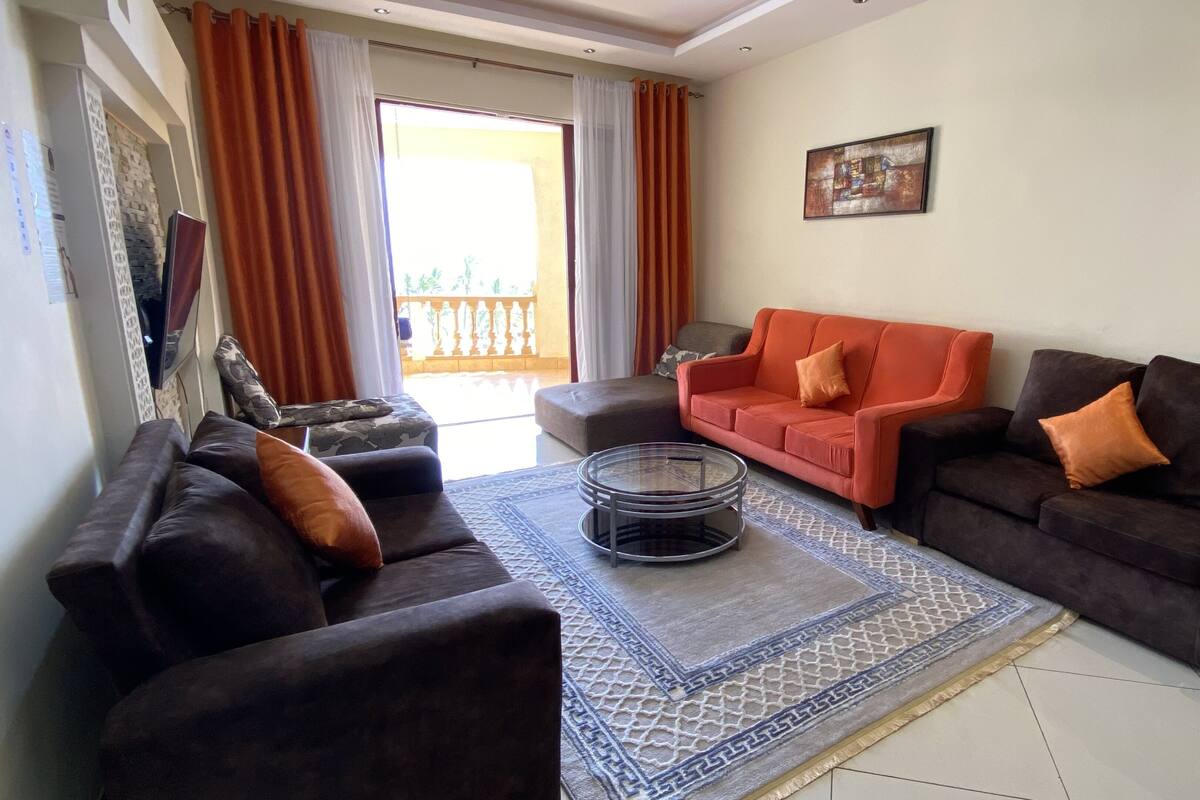 A living room with two sofas, a coffee table, and a patterned rug.