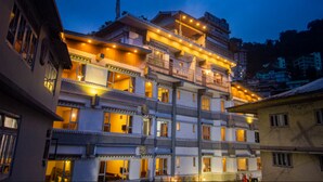 Un hotel de varios pisos con balcones e iluminación cálida.