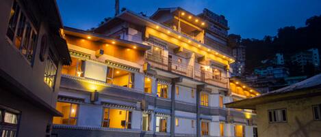 A multi-story hotel with balconies and warm lighting.
