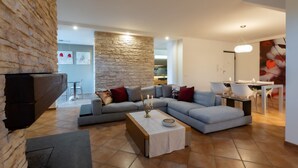 A modern living room with a sectional sofa, a coffee table, and a fireplace.