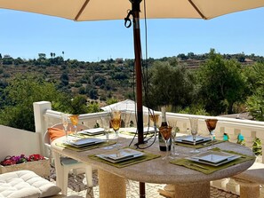 A table set for dining with a view of a hilly landscape. - Villa Botanica - Amazing villa with private pool (Silves)