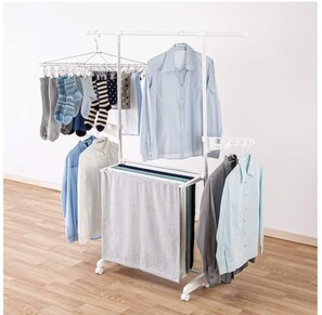 A white clothing rack with various garments hanging, a small table with a cloth, and a wooden floor. - Ikemune Bldg. 2F (Osaka)
