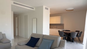 Una sala moderna con un sofá y un comedor con sillas y una mesa.