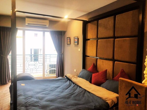 Habitación de hotel con una cama, cabecera y vistas al exterior.