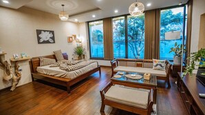 A modern room with a bed, a dining table, and a large window with curtains. - KHANG LINK (Bai Chay)
