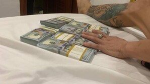 A bed with a stack of US dollar bills on it. - KHANG LINK (Bai Chay)