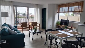 Una sala de estar con sofá, sillas, una mesa de comedor y televisor.