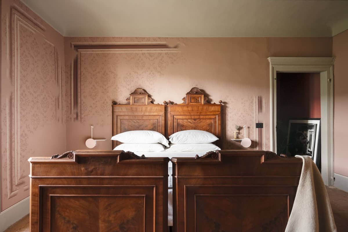 Un dormitorio con una cama de madera grande, una mesita de noche y una mesilla.