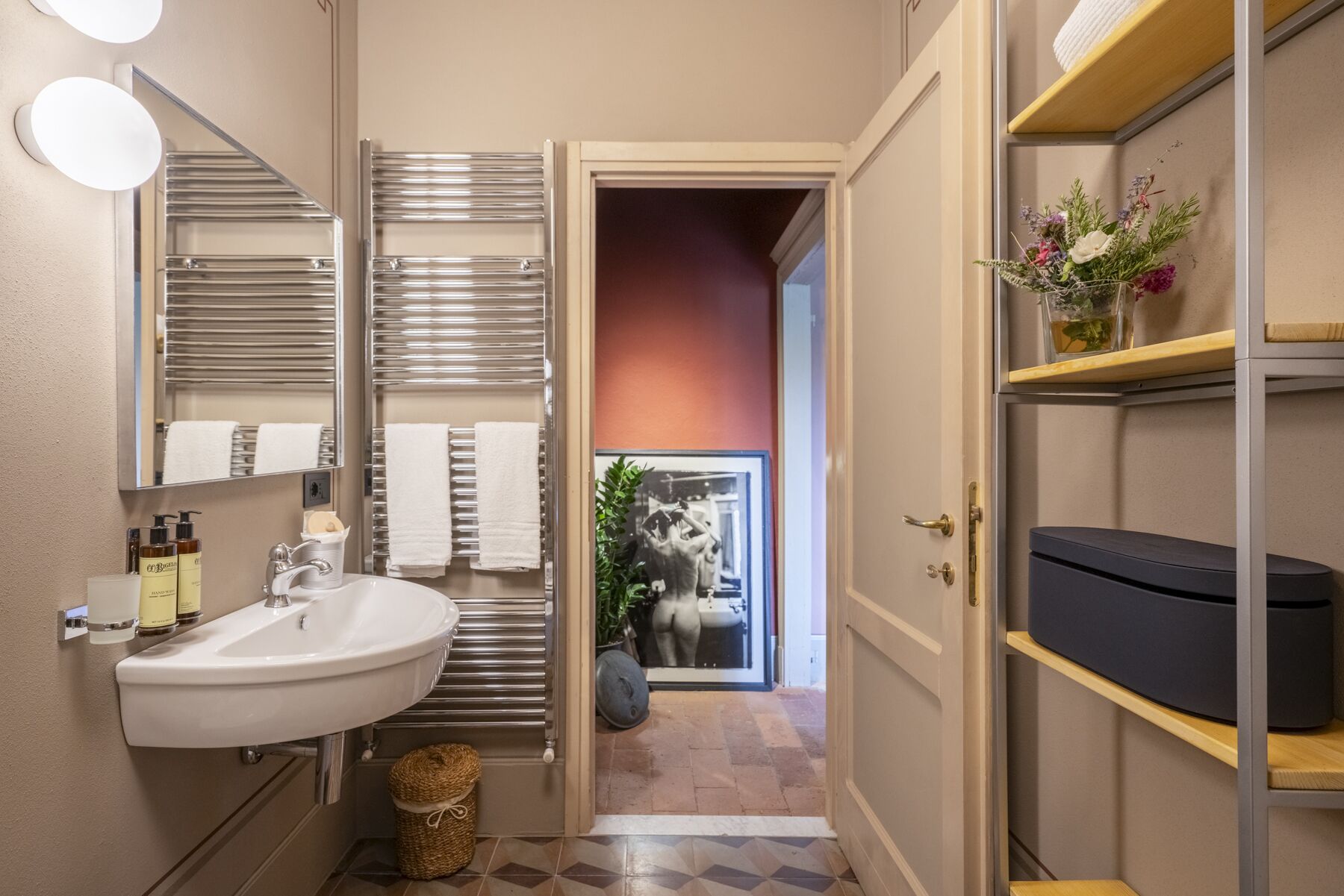 A bathroom with a sink, towel racks, a mirror, and a shower area.