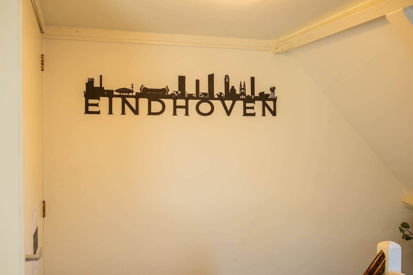 Pared con silueta de un horizonte urbano y la palabra "EINDHOVEN" en el centro.