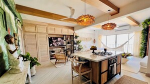 A modern kitchen with wooden cabinets, a central island, and pendant lighting.