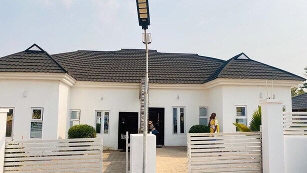 A modern two-story house with a gated entrance, a street lamp, and a paved driveway. - Flenjo Zone Bar and Apartments (Ado Ekiti)