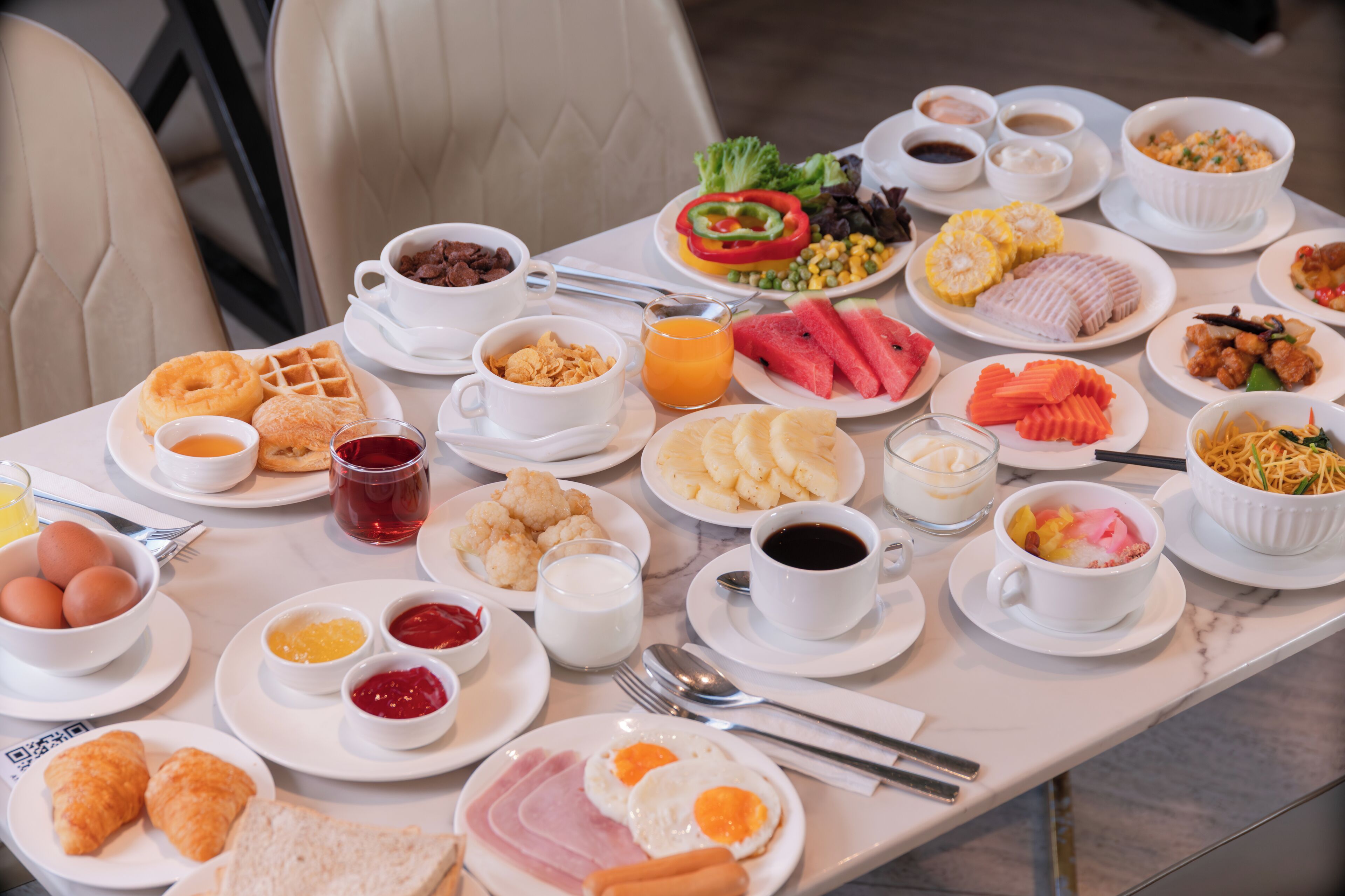 A breakfast buffet with various dishes and beverages.