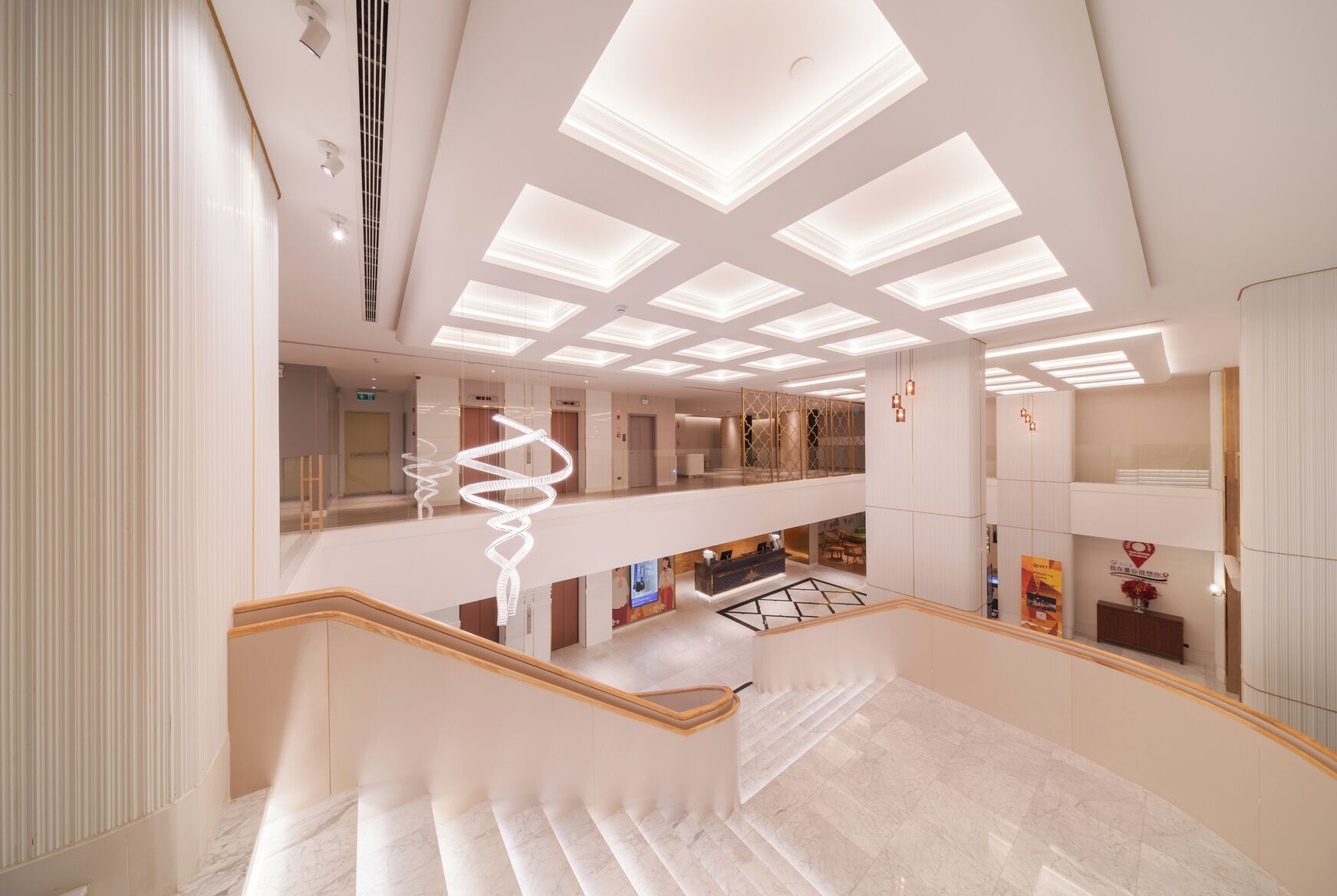 A modern interior with a central staircase, multiple levels, and a ceiling with recessed lighting.