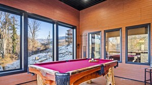 A pool table with a red felt surface, wooden legs, and a natural wood base. - Affordable AND Walk To the Strip, Hot Tub (Gatlinburg)