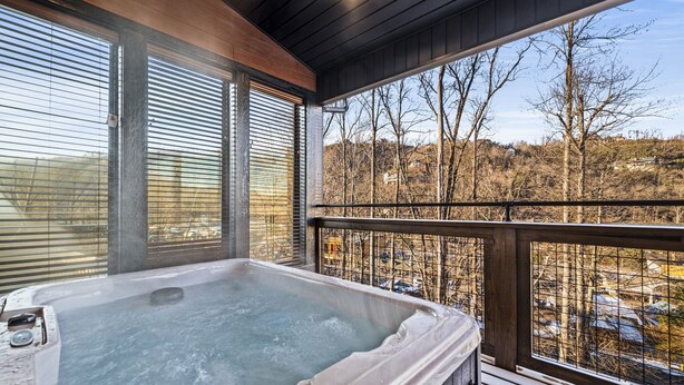 A hot tub on a wooden deck with a view of a wooded area. - Affordable AND Walk To the Strip, Hot Tub (Gatlinburg)