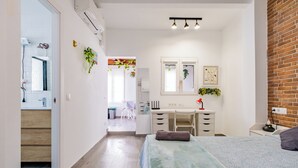 A modern bedroom with a bed, bedside table, and a desk area with a chair. - Casita Lucero (Málaga)