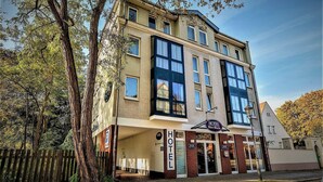 A multi-story hotel with a prominent 'HOTEL' sign at the entrance, large windows, and a traditional architectural style.
