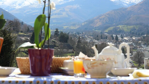 A table with a view of a valley and mountains in the background. - Krys Chambre vue sur les Pyrenees et le pis du Midi (Bagnères-de-Bigorre)