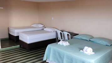 Una habitación de hotel con dos camas, una mesita y una silla.