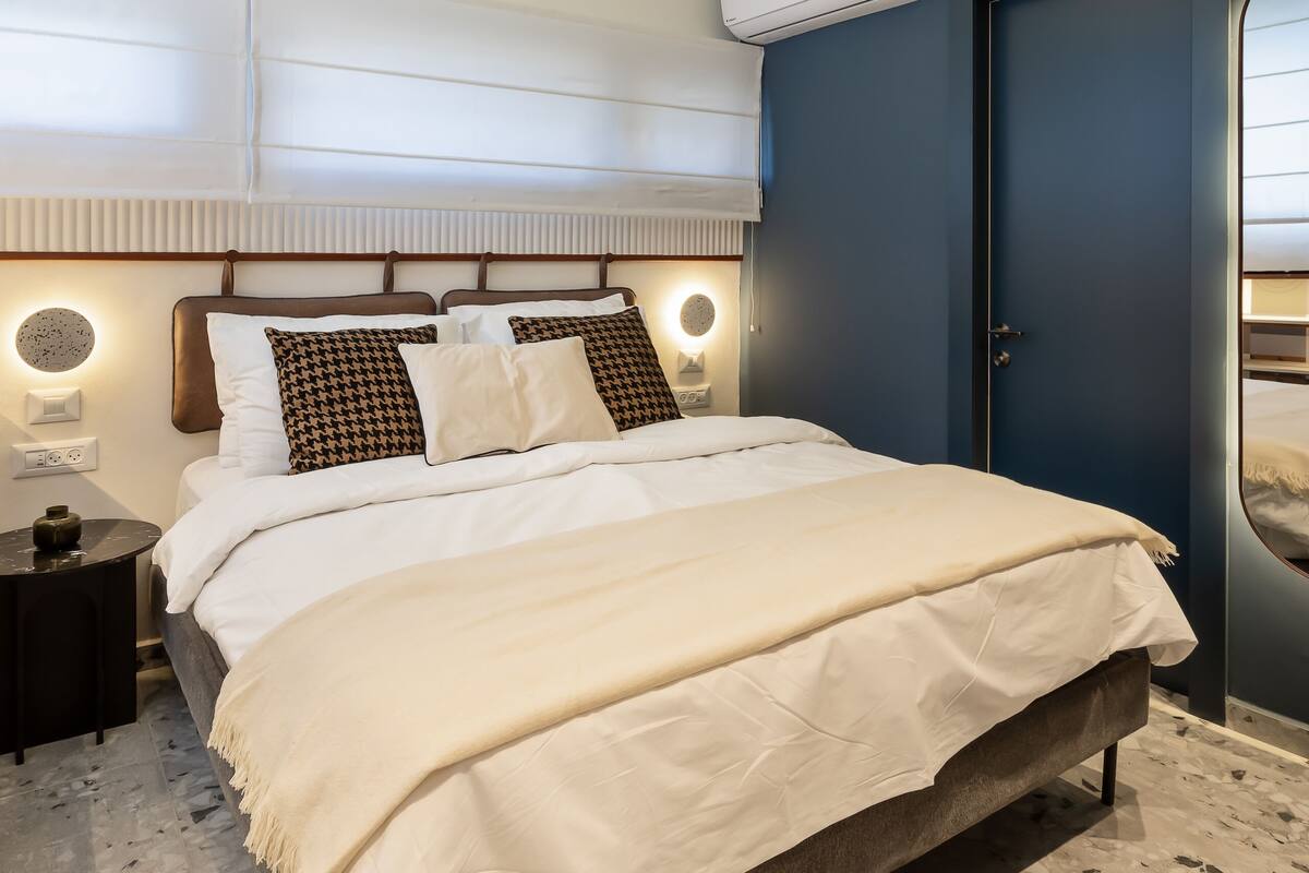 A modern bedroom with a bed, bedside tables, and a ceiling light fixture.
