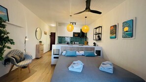 A modern bedroom with a bed, bedside tables, a desk, and a view of the kitchen. - Sunset Dream Suite El Cotillo (El Cotillo)