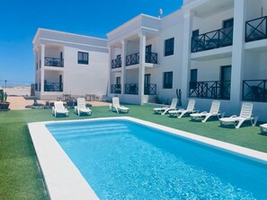 A modern hotel with a pool, white walls, and balconies. - Sunset Dream Suite El Cotillo (El Cotillo)