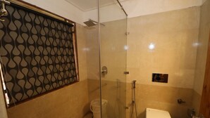 A bathroom with a glass-enclosed shower, a toilet, and a bidet. - Gezellig Inn - Golden Apple (Manali)