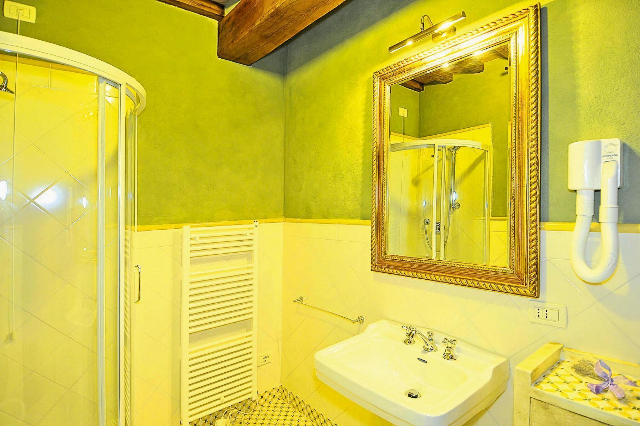 Ein Badezimmer mit Dusche, Waschbecken und Spiegel.