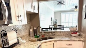 Una cocina compacta con lavavajillas, microondas y pileta.