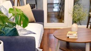 Un saló modern amb un sofà, una taula de centre i una planta en test.