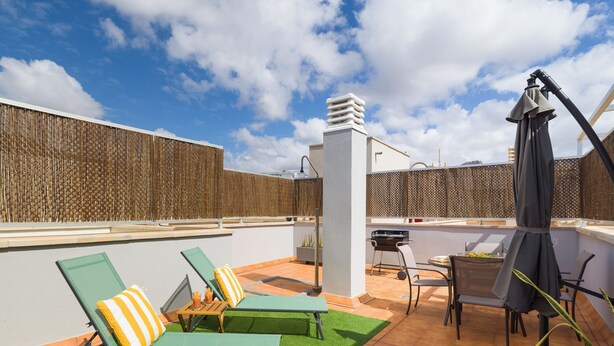 A rooftop patio with green lounge chairs, a grill, and a table with chairs. - Casa Maresía - Ocean View Penthouse, Terrace & BBQ (Sardina)