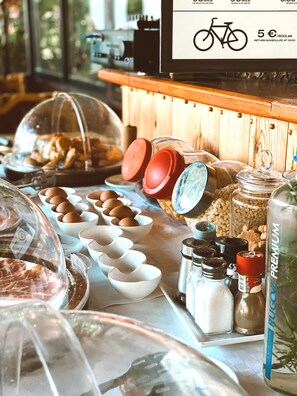 A breakfast buffet with various food items, including eggs, bread, and condiments.