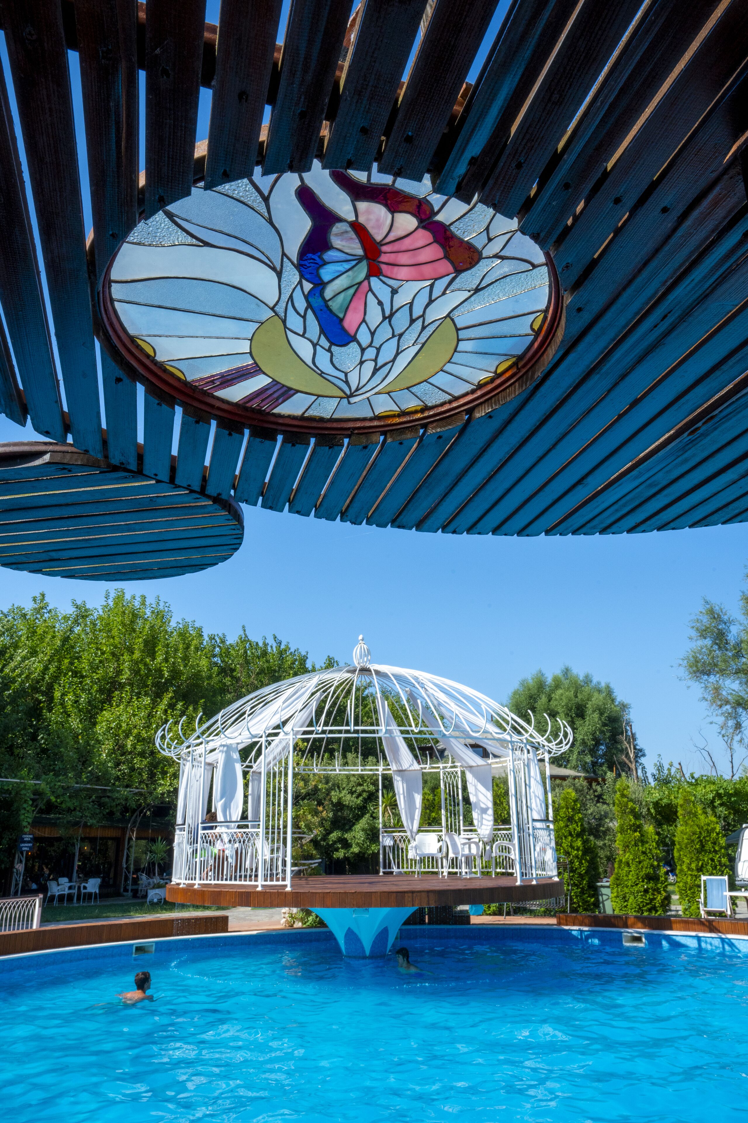 Una piscina con un pabellón y techo de vitrales.