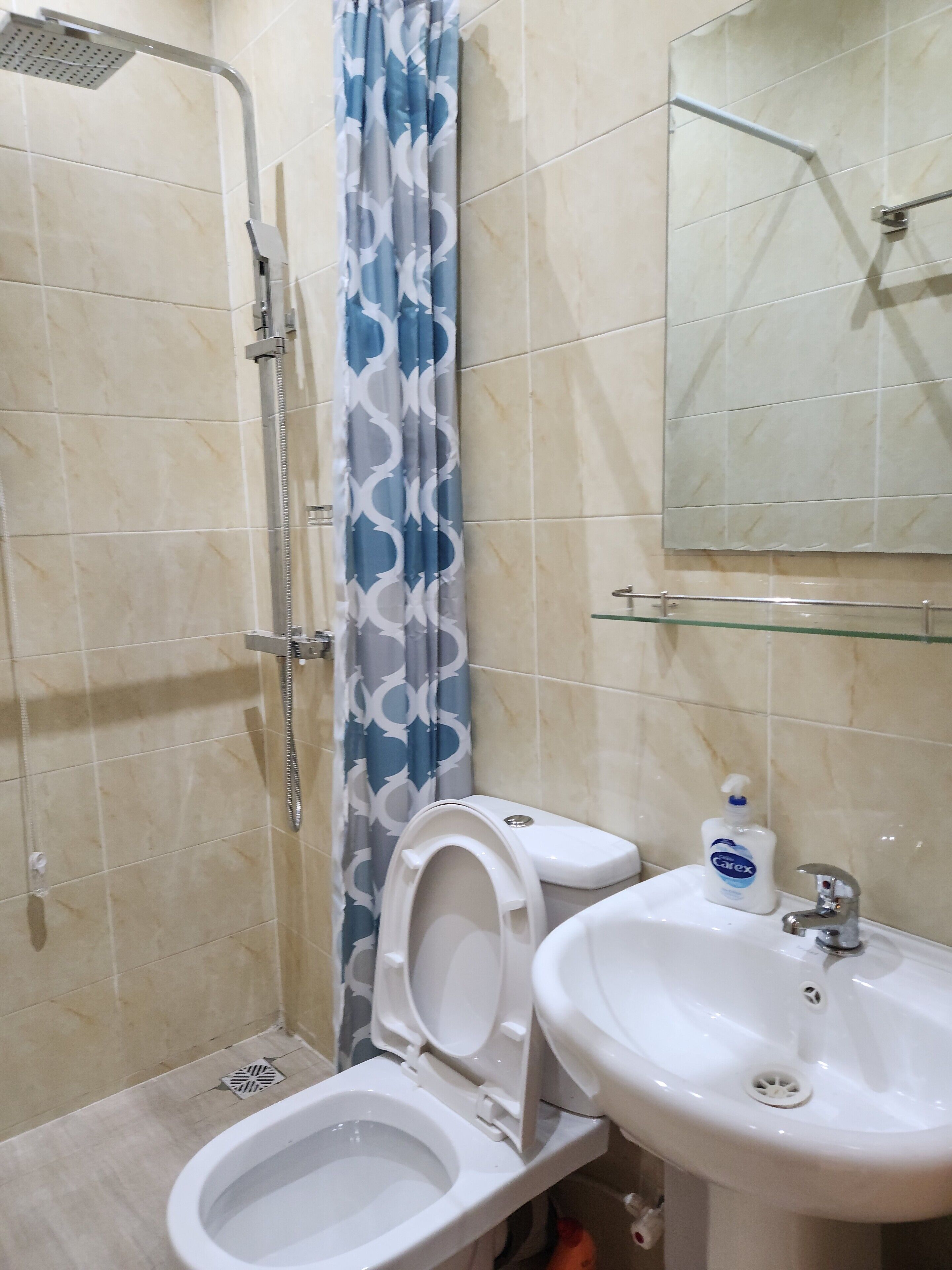 A bathroom with a shower, toilet, and sink.