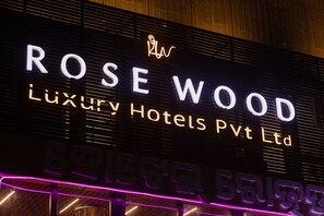 A hotel sign with "ROSEWOOD Luxury Hotels Pvt Ltd" written in illuminated letters.
