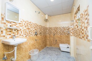 A bathroom with a sink, mirror, shower, and toilet.