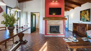 A spacious living area with a fireplace, a dining table, and a seating area. - La Vigna 4, Emma Villas (Pogi)