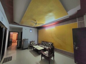 A dining area with a table and chairs, a ceiling fan, and a refrigerator. - Independent apartment in jaipur with all basic amenities  (Jaipur)