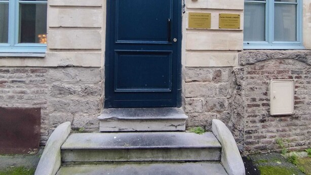 A building with a dark blue door, stone steps, and two plaques on the wall. - En Hypercentre, au Calme, Avec Cour Privative Aménagée, Appartement Rénové (Arras)