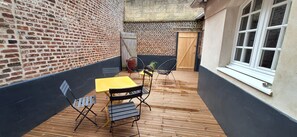 A patio with a brick wall, a wooden door, and a window. - En Hypercentre, au Calme, Avec Cour Privative Aménagée, Appartement Rénové (Arras)