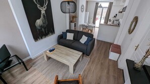 A modern living space with a sofa, coffee table, and a painting of a deer. - En Hypercentre, au Calme, Avec Cour Privative Aménagée, Appartement Rénové (Arras)