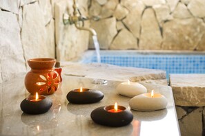 Un espacio empedrado con velas y una maceta decorativa.