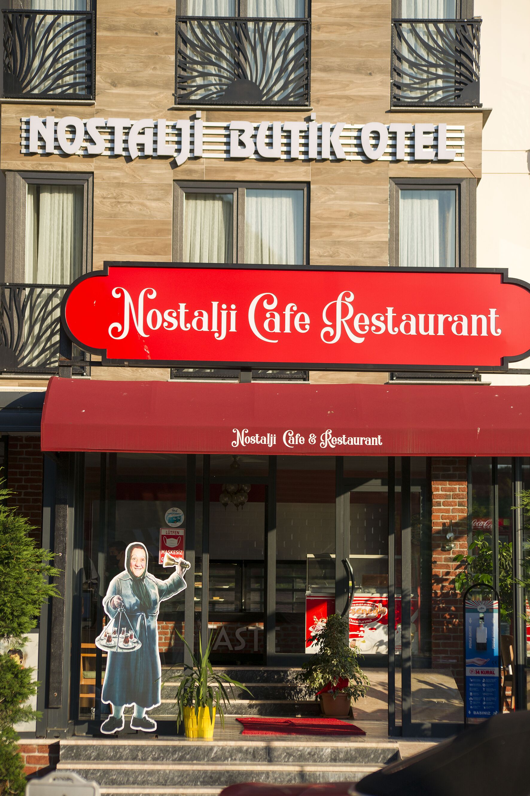 Un edificio con un letrero que dice "Nostalgia Cafe Restaurant" y un amplio escaparate.