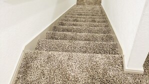 A staircase with carpeted steps and white walls. - SeaWorld & Lackland Air Force Base Modern Home (San Antonio)